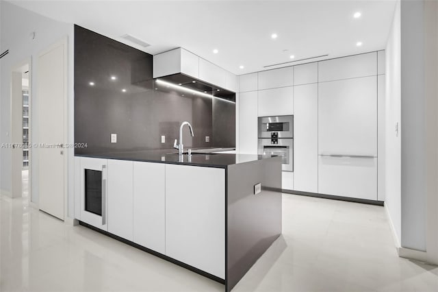 kitchen featuring decorative backsplash, white cabinets, light tile patterned floors, double oven, and sink