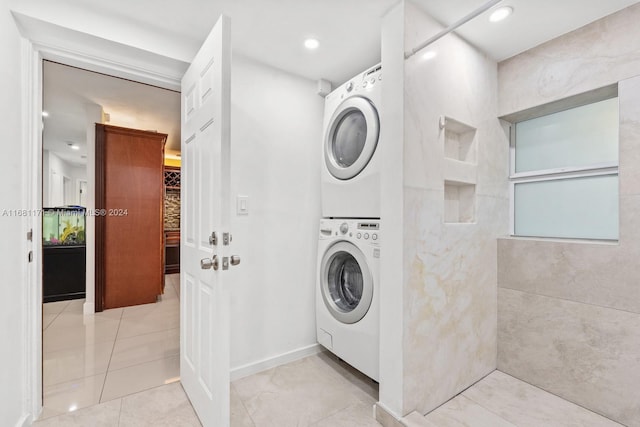 laundry area with tile walls and stacked washer / dryer