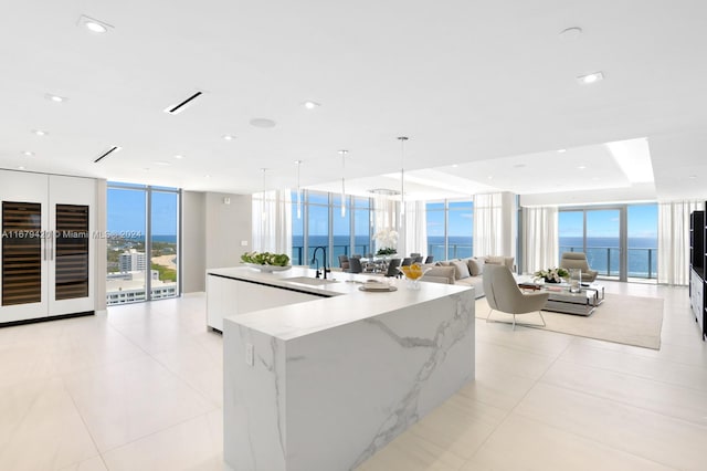 kitchen with a spacious island, a water view, a wealth of natural light, and floor to ceiling windows