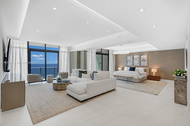 bedroom with floor to ceiling windows and a water view