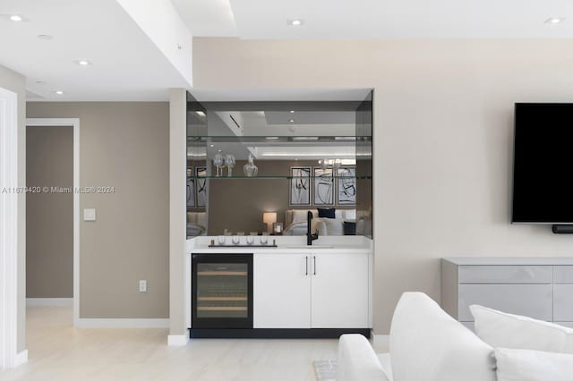 bar with white cabinetry, wine cooler, and sink