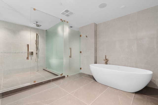 bathroom with plus walk in shower, tile walls, and tile patterned flooring