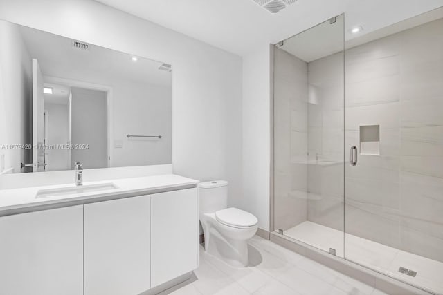 bathroom with vanity, tile patterned floors, toilet, and an enclosed shower