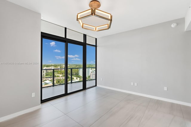 tiled spare room featuring floor to ceiling windows