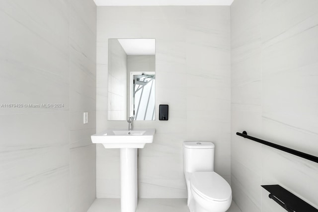 bathroom featuring toilet and tile walls