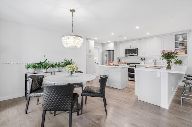 dining space featuring light hardwood / wood-style floors and an inviting chandelier