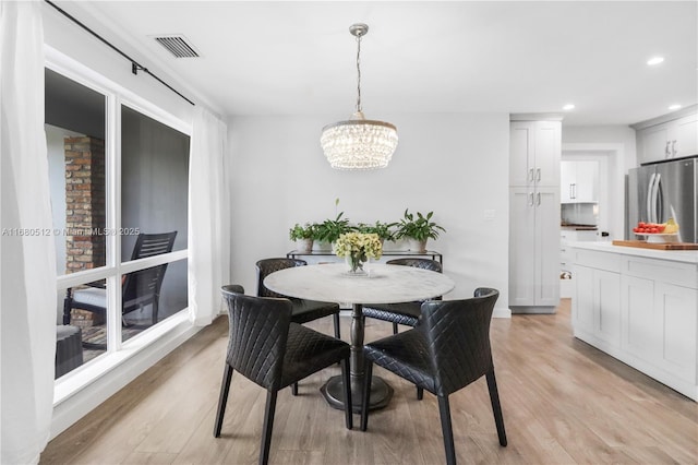 dining area featuring a notable chandelier and light wood-type flooring