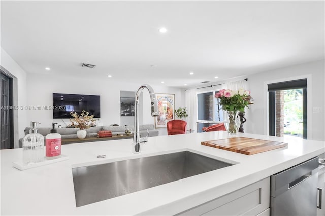 kitchen featuring dishwasher, white cabinetry, and sink