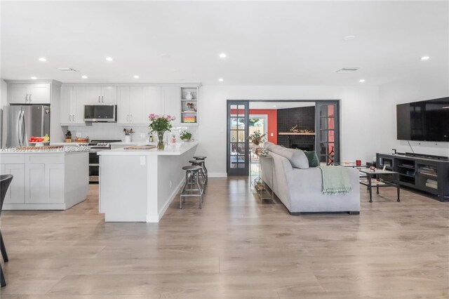 living room with sink and light hardwood / wood-style floors