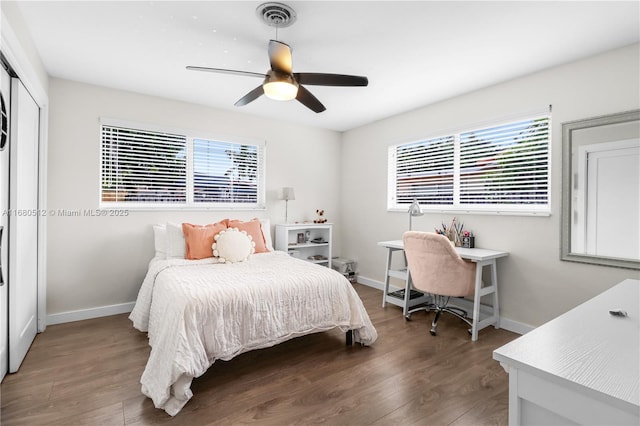 bedroom with ceiling fan, dark hardwood / wood-style flooring, and multiple windows