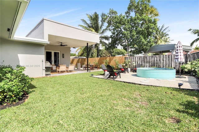 view of yard with ceiling fan, a patio area, and a swimming pool