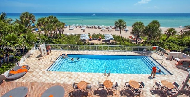 view of pool with a patio area and a water view