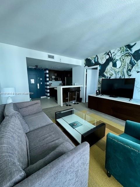 living room featuring a textured ceiling and carpet floors