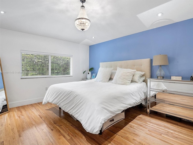 bedroom with wood-type flooring and a notable chandelier