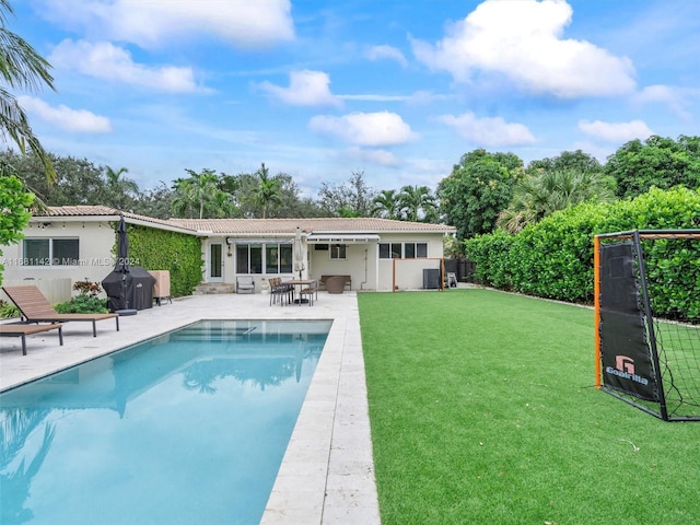 view of swimming pool featuring a patio and a yard