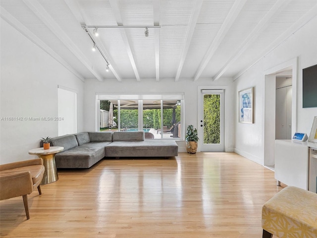 living room featuring light hardwood / wood-style flooring, rail lighting, and beam ceiling