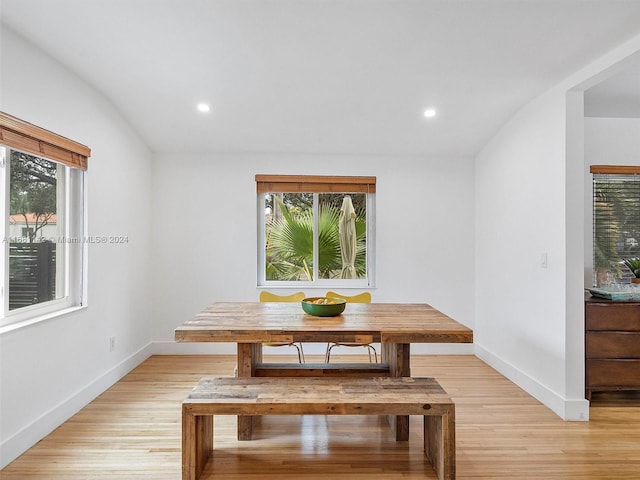 unfurnished dining area featuring light wood-type flooring and lofted ceiling