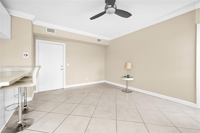 unfurnished room with ceiling fan, ornamental molding, and light tile patterned flooring