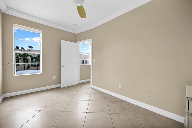 spare room featuring crown molding, light tile patterned floors, and ceiling fan