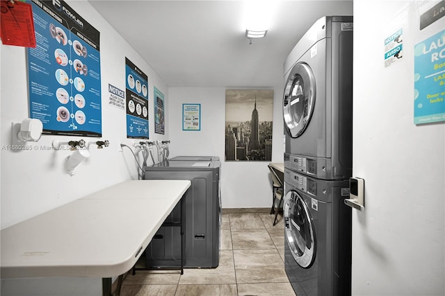 washroom with stacked washer / dryer and light tile patterned floors