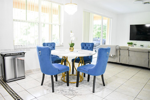 tiled dining space featuring an inviting chandelier