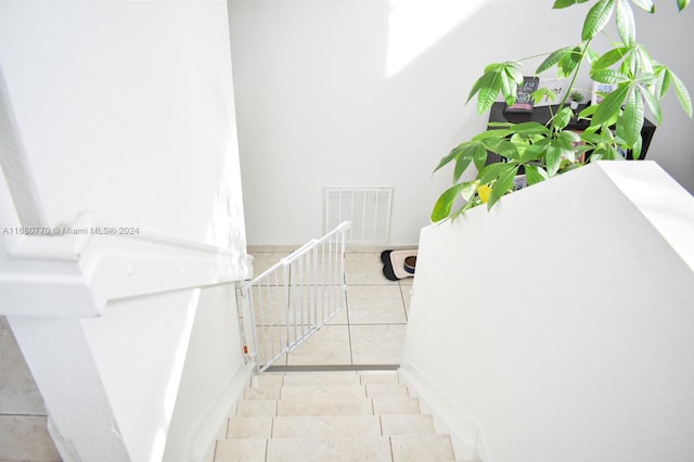 staircase featuring tile patterned flooring