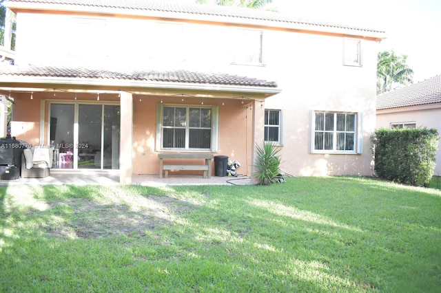 back of house with a lawn and a patio area