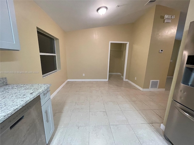 unfurnished living room with lofted ceiling and light tile patterned floors