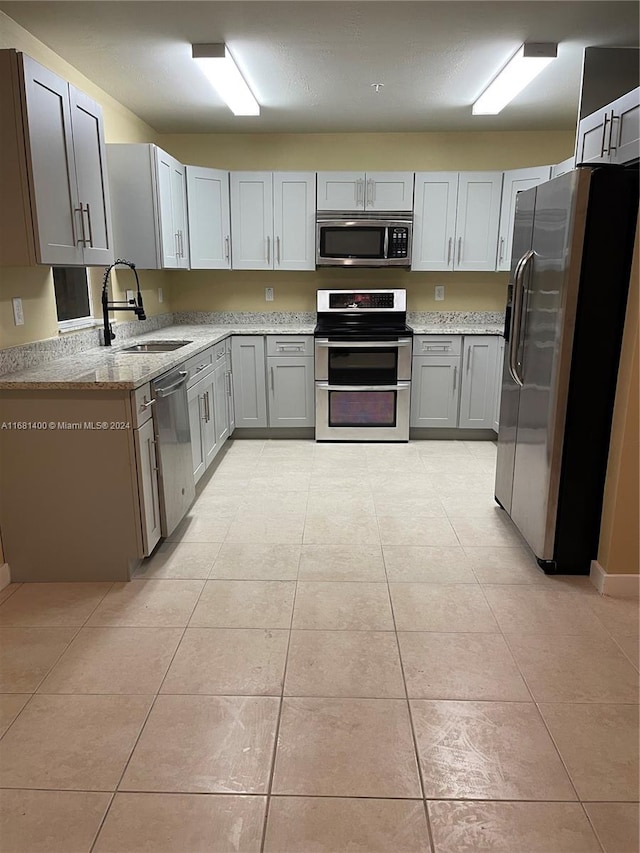 kitchen featuring appliances with stainless steel finishes, sink, and gray cabinets