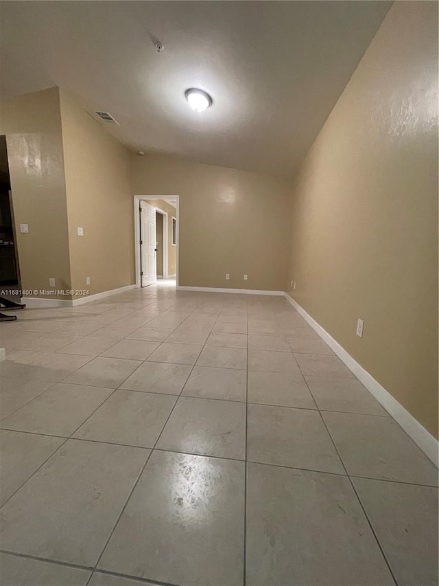 tiled spare room with lofted ceiling