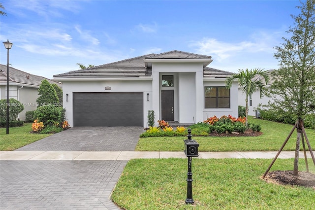 view of front of home with a garage and a front lawn