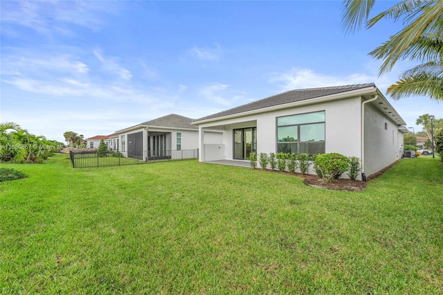 back of property with a sunroom and a yard