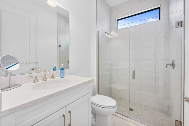 bathroom featuring vanity, toilet, and a shower with shower door