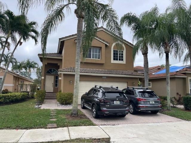 mediterranean / spanish house featuring a garage and a front lawn