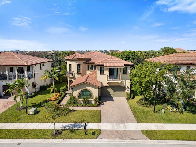 mediterranean / spanish house with a balcony, a garage, and a front lawn