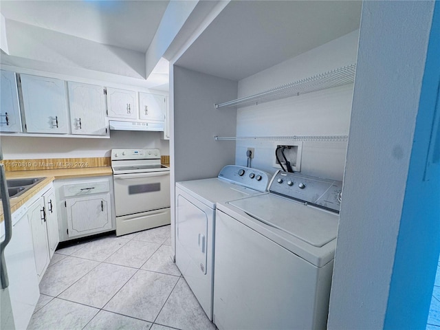 laundry area featuring sink, washer and clothes dryer, and light tile patterned flooring