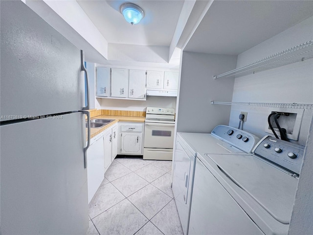 washroom featuring sink, separate washer and dryer, and light tile patterned floors