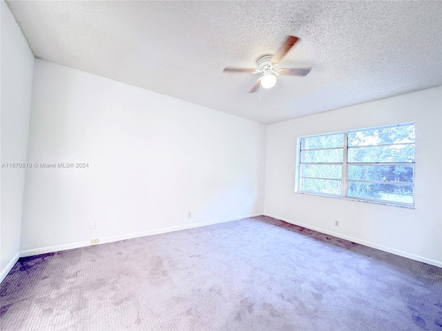 spare room with ceiling fan, carpet, and a textured ceiling