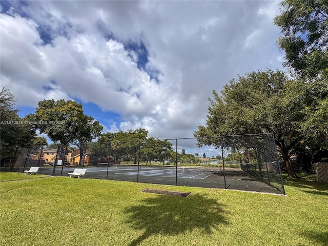 view of tennis court featuring a lawn