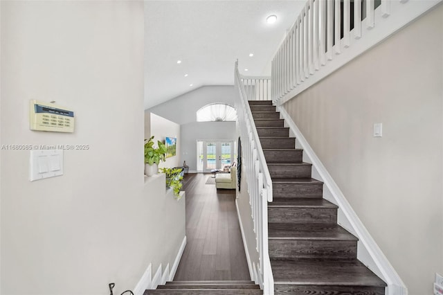 staircase with high vaulted ceiling, recessed lighting, wood finished floors, baseboards, and french doors