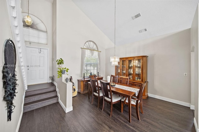 dining area with dark wood-type flooring, visible vents, baseboards, and an inviting chandelier