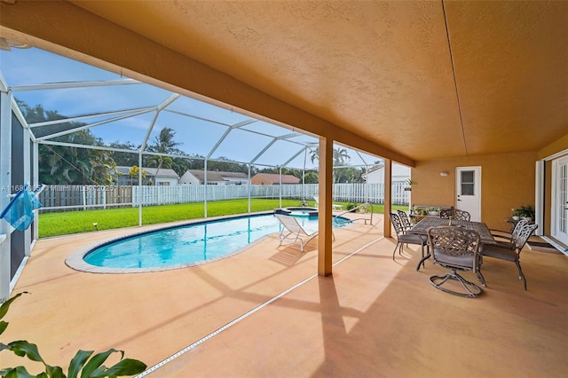 view of pool featuring glass enclosure, a fenced backyard, and a patio