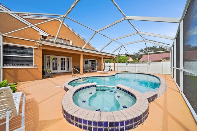 view of swimming pool featuring glass enclosure, fence, a pool with connected hot tub, french doors, and a patio area