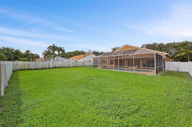 view of yard with glass enclosure, a fenced backyard, and a fenced in pool