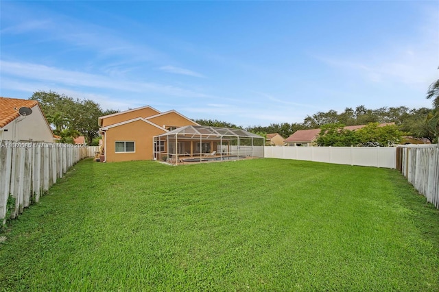 view of yard with glass enclosure and a fenced backyard