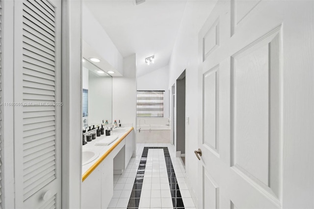 full bath with double vanity, a closet, a garden tub, tile patterned flooring, and a sink