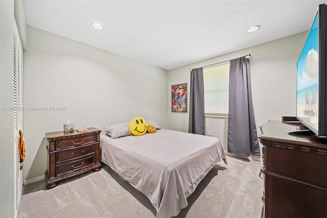 bedroom with light carpet, a textured ceiling, baseboards, and recessed lighting