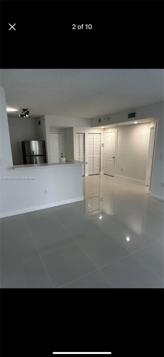 unfurnished living room with dark tile patterned flooring