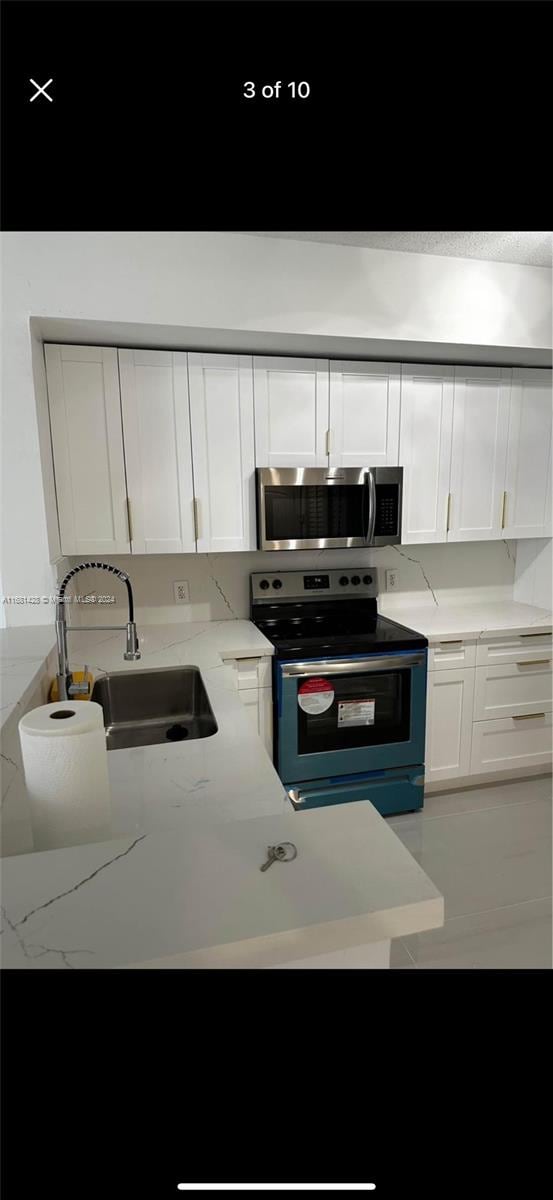 kitchen with white cabinetry, stainless steel appliances, and sink