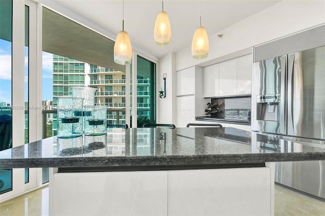 kitchen with pendant lighting, white cabinets, stainless steel fridge, and light tile patterned floors